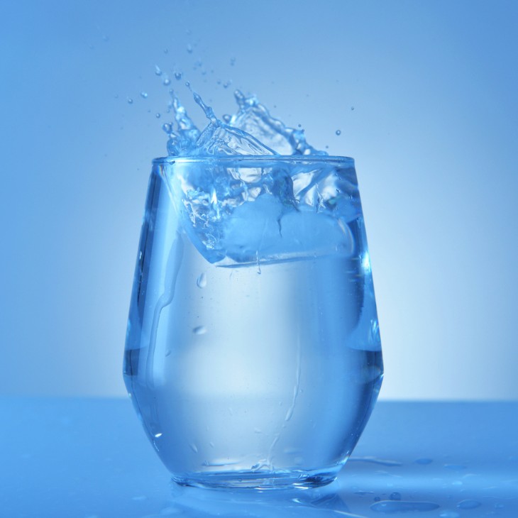 Water in een beker met blauw achtergrond